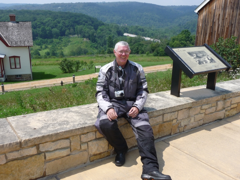 Boyd sitting on a wall in front of the valley that flooded